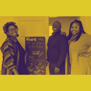 Three smiling Black people stand around a chalkboard sign. There is a yellow filter overlay on top.