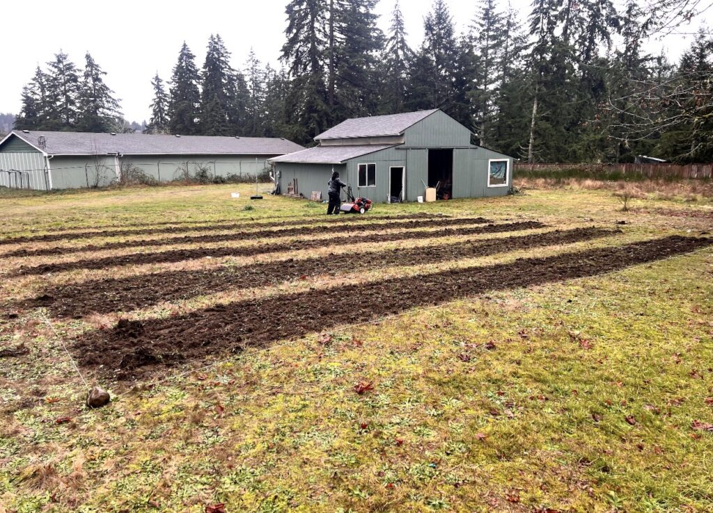 A photo of a Black farmer mowing and tilling on JT's farmland.